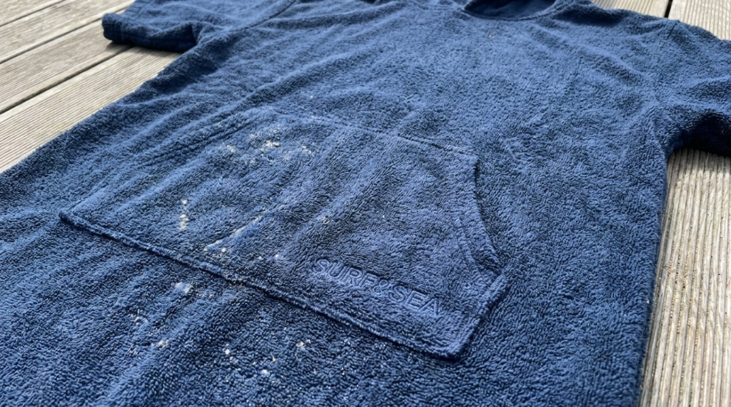 Close up of a thick terry cloth changing towel robe with a front pocket.